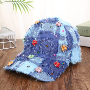 Blue-patchwork-denim-baseball-cap-featuring-distressed-frayed-edges-and-colorful-pearl-jewel-rhinestones-flower-cluster-embellishments-on-a-wooden-background-4