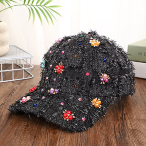 Blue-patchwork-denim-baseball-cap-featuring-distressed-frayed-edges-and-colorful-pearl-jewel-rhinestones-flower-cluster-embellishments-on-a-wooden-background-5