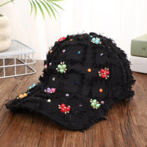 Blue-patchwork-denim-baseball-cap-featuring-distressed-frayed-edges-and-colorful-pearl-jewel-rhinestones-flower-cluster-embellishments-on-a-wooden-background-6