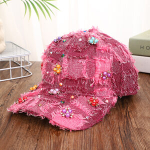 Blue-patchwork-denim-baseball-cap-featuring-distressed-frayed-edges-and-colorful-pearl-jewel-rhinestones-flower-cluster-embellishments-on-a-wooden-background-8