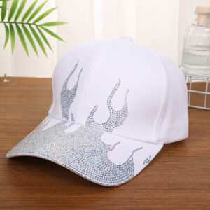White-baseball-cap-featuring-a-shiny-crystal-rhinestone-flame-pattern-on-the-front-and-brim-placed-on-a-wooden-table-2
