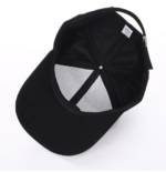 White-baseball-cap-featuring-a-shiny-crystal-rhinestone-flame-pattern-on-the-front-and-brim-placed-on-a-wooden-table-4