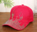 White-baseball-cap-featuring-a-shiny-crystal-rhinestone-flame-pattern-on-the-front-and-brim-placed-on-a-wooden-table-6