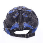 Wholesale-washed-black-denim-baseball-cap-with-custom-distressed-ripped-holes-revealing-a-bright-blue-underlayer-displayed-for-bulk-clothing-supplier-1