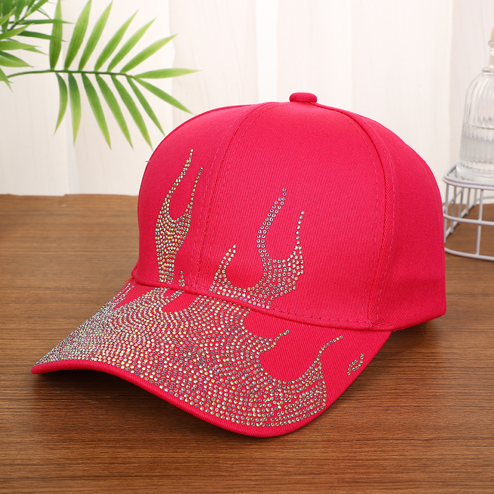 White-baseball-cap-featuring-a-shiny-crystal-rhinestone-flame-pattern-on-the-front-and-brim-placed-on-a-wooden-table-6